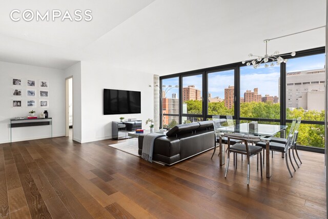 living room with a wall of windows, plenty of natural light, and dark hardwood / wood-style floors