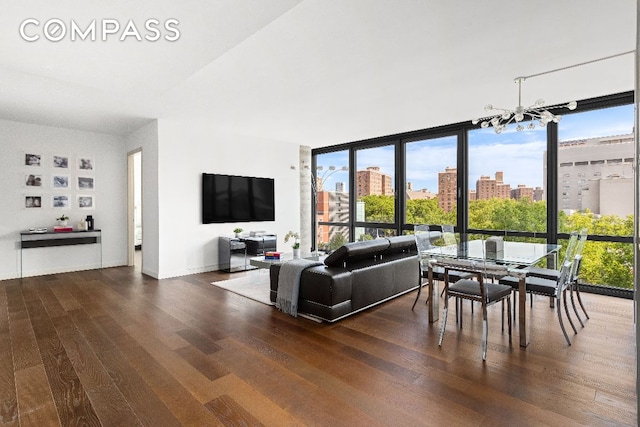 living room with expansive windows, dark wood-type flooring, a wealth of natural light, and a notable chandelier