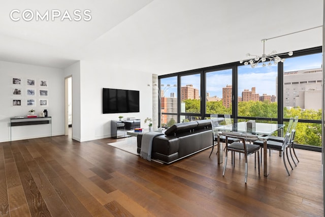 living room with a chandelier, dark wood-style flooring, floor to ceiling windows, and plenty of natural light