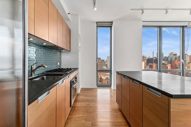 kitchen with expansive windows, a spacious island, and light wood-type flooring