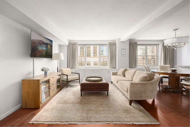 living area with dark wood-style floors, baseboards, and an inviting chandelier