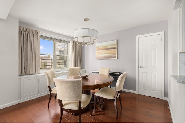 dining area featuring dark wood-style floors, a chandelier, and baseboards