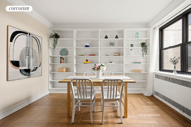 dining room featuring crown molding, radiator, and light parquet floors