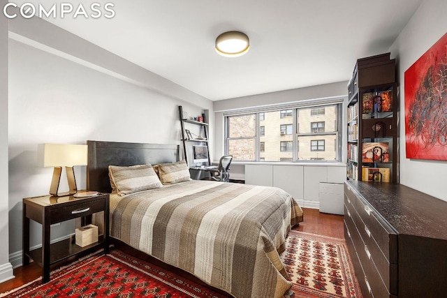 bedroom with dark hardwood / wood-style flooring