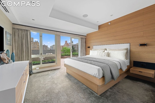 carpeted bedroom featuring access to outside and wooden walls