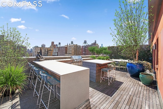 deck featuring exterior bar, an outdoor kitchen, and grilling area