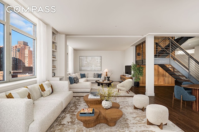 living room featuring dark wood-type flooring and built in features