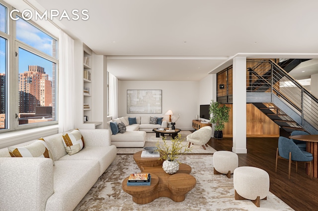 living area with baseboards, stairway, wood finished floors, a view of city, and built in shelves