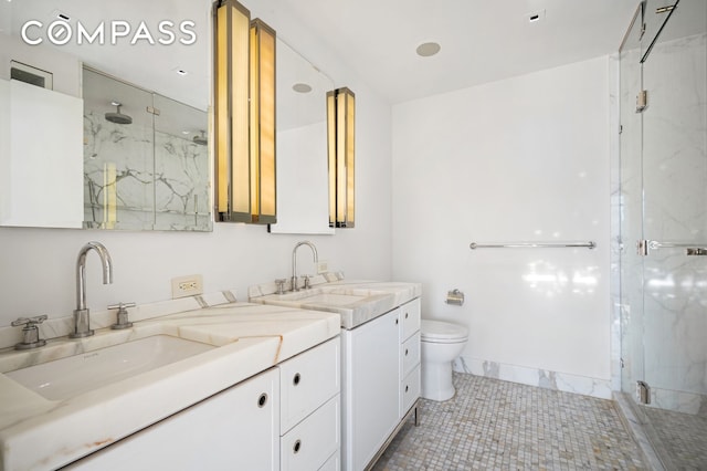 full bathroom with a marble finish shower, toilet, and vanity