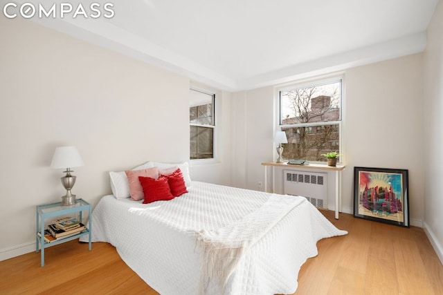 bedroom featuring wood-type flooring and radiator