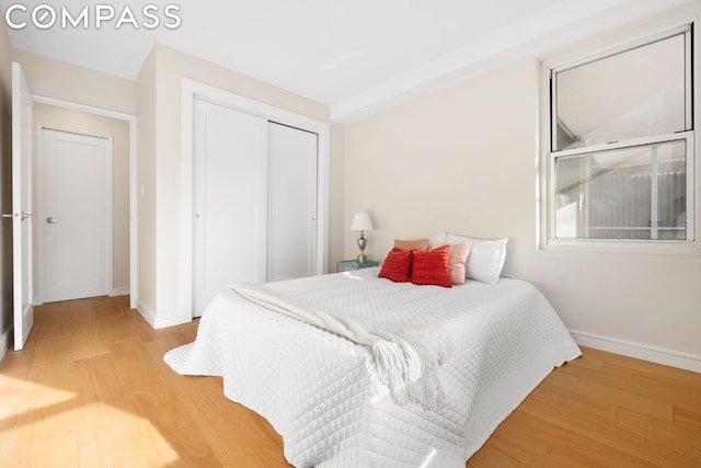 bedroom with a closet and light hardwood / wood-style flooring