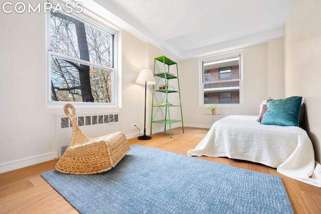 bedroom with hardwood / wood-style flooring and radiator heating unit