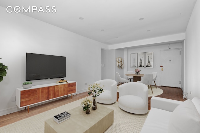 living area featuring baseboards and wood finished floors