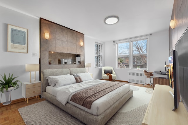 bedroom featuring radiator and light parquet floors