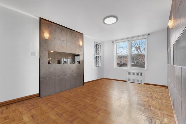 unfurnished room with radiator and light parquet floors