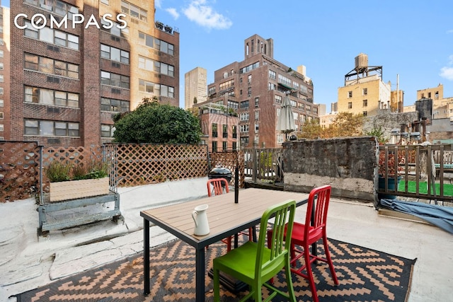 view of patio / terrace featuring a view of city and fence