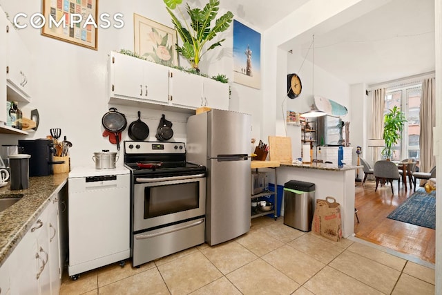 kitchen featuring white cabinets, appliances with stainless steel finishes, light stone counters, open shelves, and light tile patterned flooring