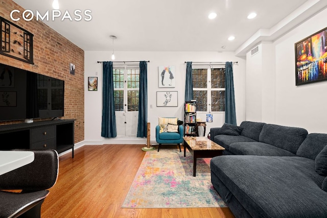 living area with recessed lighting, visible vents, light wood-style flooring, and baseboards