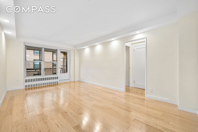 spare room featuring light wood-type flooring, baseboards, and recessed lighting