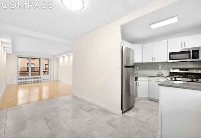 kitchen with backsplash, sink, white cabinetry, and appliances with stainless steel finishes