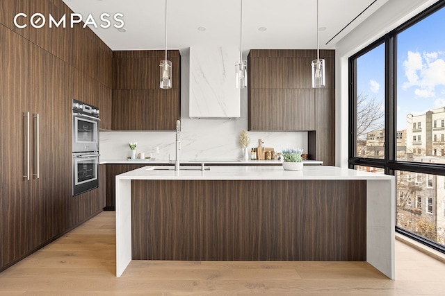 145 Conselyea St, New York City, NY 11211 - kitchen with modern cabinets, a sink, light countertops, double oven, and light wood-style flooring
