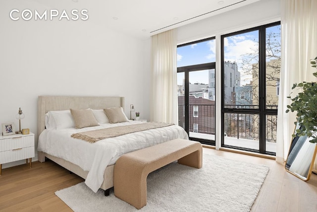 bedroom featuring light wood-type flooring and access to outside