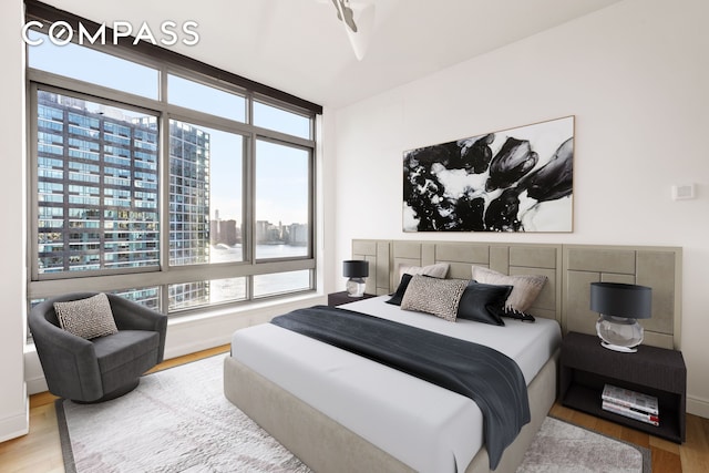 bedroom featuring a view of city and wood finished floors