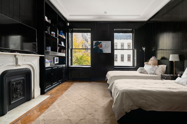 bedroom featuring ornamental molding, light parquet flooring, and wood walls