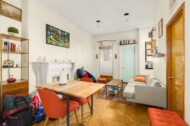 kitchen featuring radiator heating unit, tasteful backsplash, light stone counters, stainless steel appliances, and light hardwood / wood-style flooring