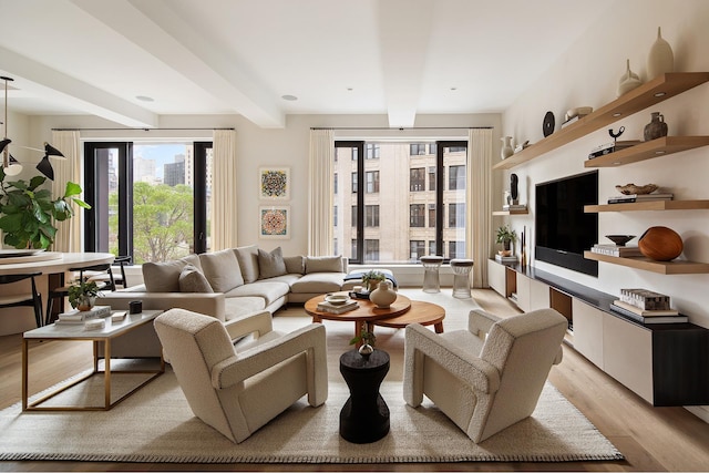 living area featuring beam ceiling and light wood-style flooring