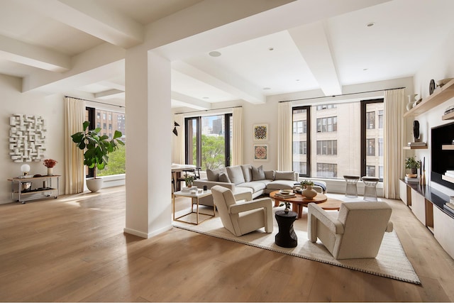 living room featuring baseboards, beam ceiling, and light wood finished floors