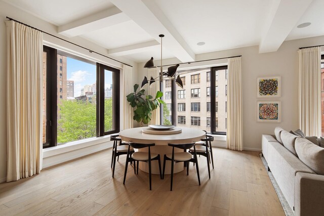 bedroom with beamed ceiling, built in desk, and hardwood / wood-style floors