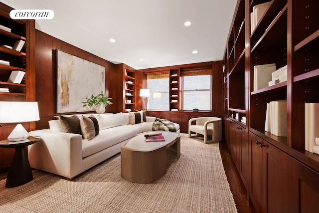 sitting room featuring recessed lighting, built in features, light wood-style flooring, and wooden walls