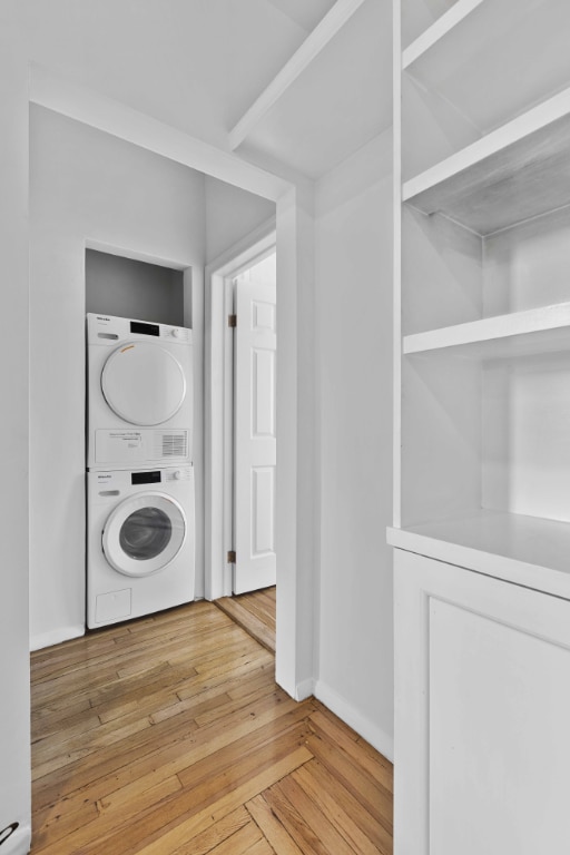 washroom featuring stacked washer / dryer and hardwood / wood-style floors