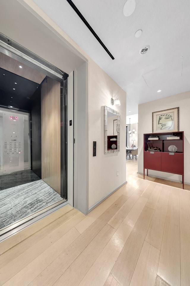 corridor featuring recessed lighting and light wood-style floors