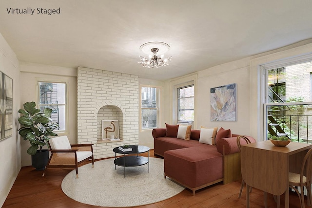 sitting room featuring a fireplace, an inviting chandelier, and wood finished floors