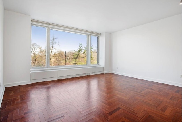 spare room featuring dark parquet floors