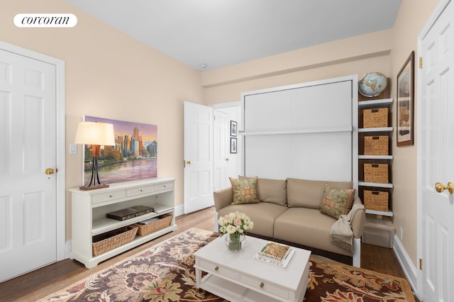 living room featuring wood finished floors, visible vents, and baseboards