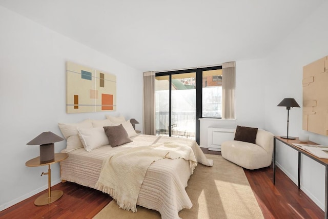 bedroom featuring wood-type flooring and access to outside