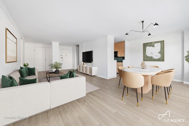 dining area featuring ornamental molding and light hardwood / wood-style floors