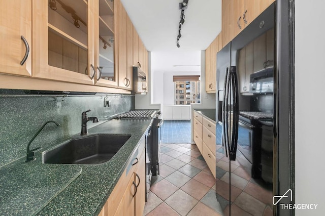 kitchen featuring stainless steel gas stove, sink, decorative backsplash, light tile patterned floors, and black fridge with ice dispenser