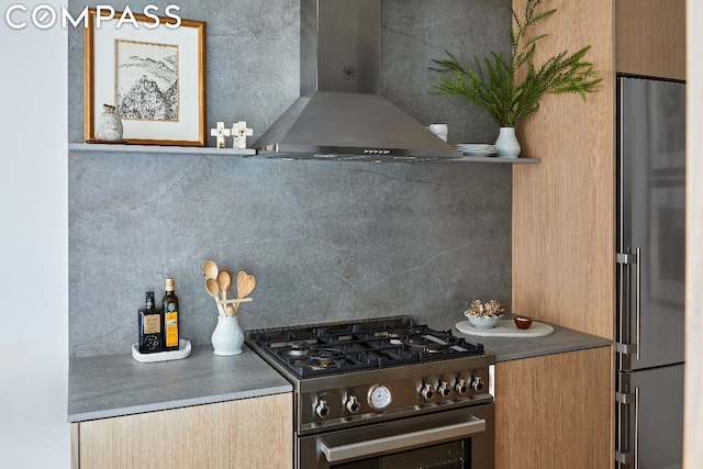 kitchen with decorative backsplash, high end refrigerator, exhaust hood, and gas stove