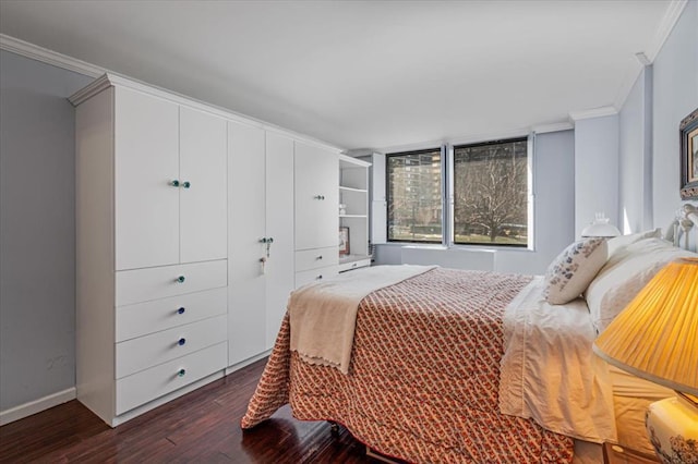 bedroom with crown molding and dark hardwood / wood-style flooring