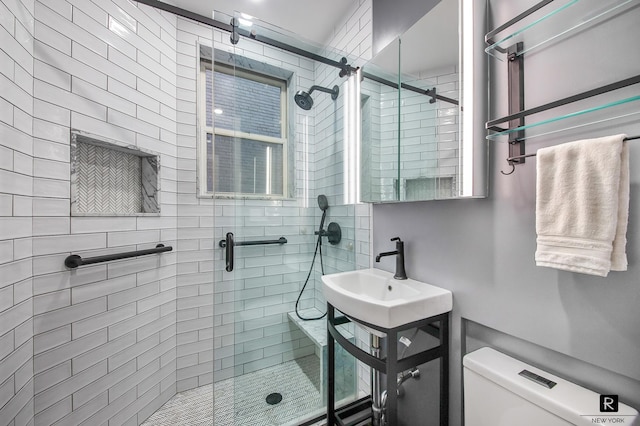 full bathroom with a sink, toilet, and a shower stall