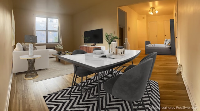 dining space featuring baseboards and light wood-style flooring