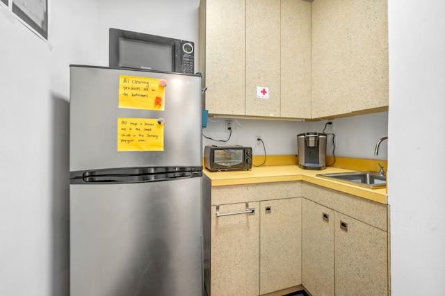 kitchen featuring sink and stainless steel refrigerator