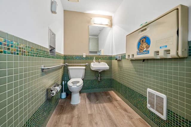 bathroom featuring hardwood / wood-style flooring, sink, tile walls, and toilet