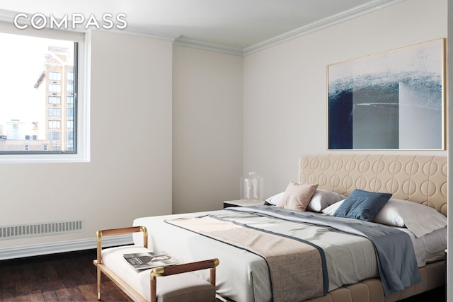 bedroom with visible vents, baseboards, wood finished floors, and crown molding