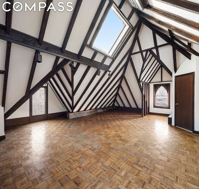 unfurnished living room with beam ceiling, high vaulted ceiling, and dark parquet floors