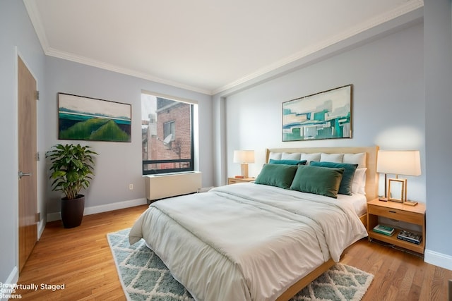 bedroom featuring crown molding and light wood-type flooring